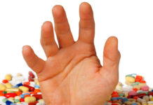 Beste psychiater, ik stierf bijna onder jouw ‘zorg’ Verdrinken in de pillen. Een hand komt nog net boven het pillenwater uit.