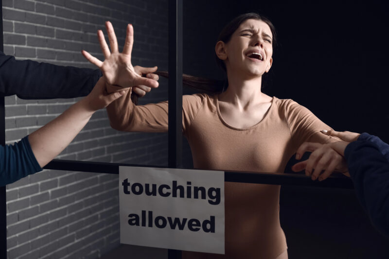 Vrouw in kooi met tekst "aanraken toegestaan"