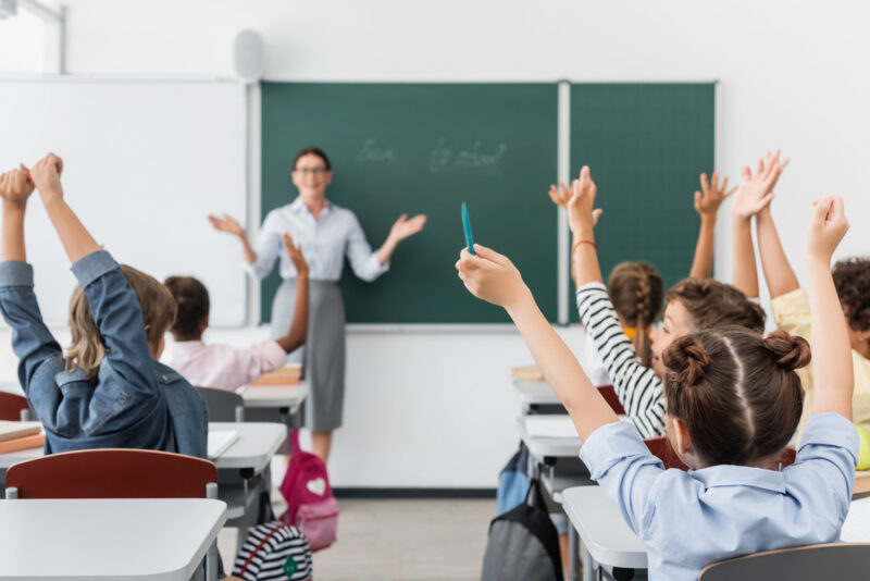 De leraar weet het niet, de kinderen steken hun vinger op. Het symbolisch stemmen wie de pillen uit de klas wil.